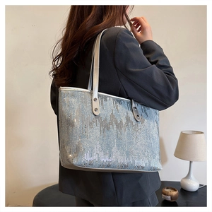 Detail of silver sequin tote bag showing textured mountain pattern and leather straps