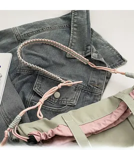 Detail of sage green canvas bag showing woven pink and white rope shoulder straps