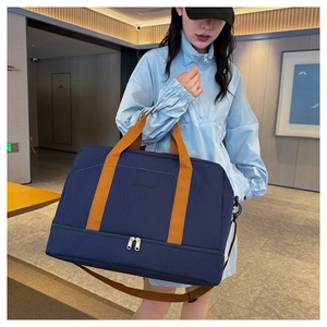 Détail du sac de voyage en nylon bleu avec sangles oranges et compartiment à chaussures