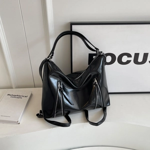 Glossy black bow tote bag with silver zippers and spacious design for modern women