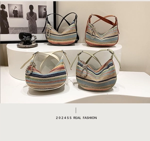 Detailed view of colorful striped straw crescent bags with leather straps and pearl charms