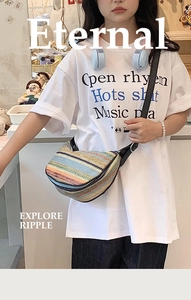 Detail of colorful striped straw crossbody bag with adjustable black strap worn by a model