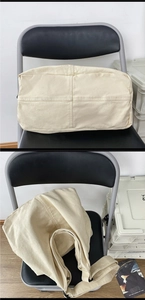 Detail view of reinforced bottom stitching and wide strap on beige canvas tote bag