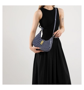 Détail du sac bandoulière bleu texture crocodile avec fermoir en métal doré brillant