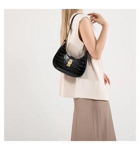 Détail du sac à bandoulière noir motif crocodile avec boucle en métal doré élégante