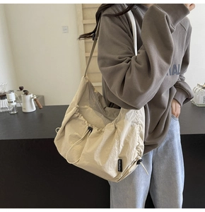 Detail of the draw-string ruched design on this beige large capacity shoulder bag