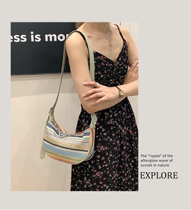 Detail of colorful striped woven straw shoulder bag with leather strap and metal rings