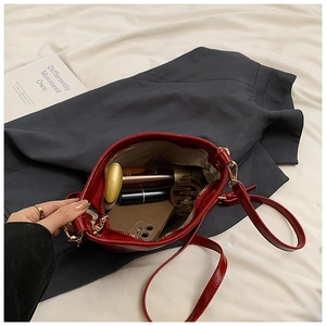 Interior view showing large capacity for essentials in a red shiny patent leather bag