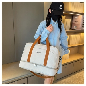 Détail du sac de voyage crème avec poignées marron et compartiment à chaussures