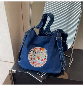 Detailed view of dragon embroidery on a premium denim tote bag with high-quality texture