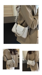 Detail view of silver embossed crocodile texture shoulder bag with bead chain handle