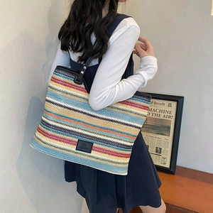 Colorful woven tote bag with horizontal stripes and black leather handles for summer