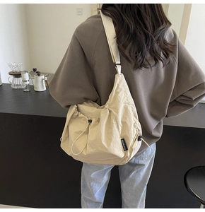 Detail shot of a beige nylon drawstring bag featuring the OUPINFAN brand side label