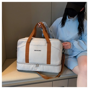 Détail du sac de voyage gris avec compartiment à chaussures et bandoulière amovible