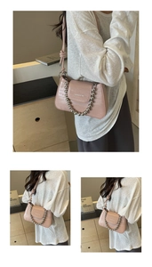 Detail view of pink crocodile pattern handbag with silver bead chain and knotted strap