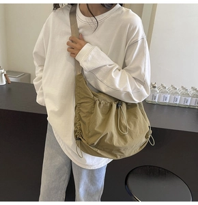 Close-up of khaki nylon tote showing drawstring design and adjustable shoulder strap detail