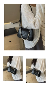 Close-up of black crocodile pattern bag with silver bead chain and fashion branding