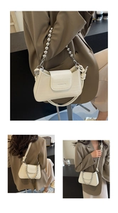 Detail of cream crocodile embossed handbag with silver bead chain and knotted strap