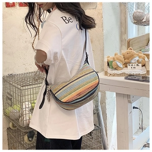 Detail of multi-color striped woven crossbody bag with silver pearl bag charm
