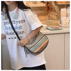 Detailed macro of a multi-color striped woven crossbody bag with bohemian style finish