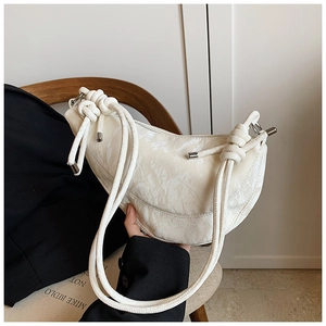 Detail of hobo bag with pleated texture, rope knot strap, and silver metal finish