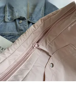 Detail of pink crossbody bag showing smooth zipper closure and reinforced stitching quality