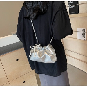 Détail du sac seau plissé argenté avec chaîne en métal et breloque en perle