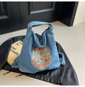 Detail of light blue denim tote bag with exquisite Chinese dragon embroidery patch