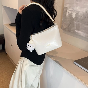 Chic off-white shoulder bag with braided strap and plush ball charm for women