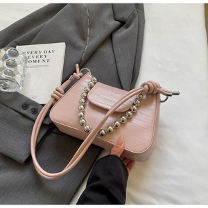 Detail of pink faux crocodile leather texture and thick silver bead chain handle