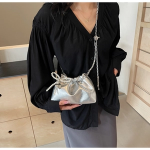 Détail du sac seau argenté métallisé avec bandoulière en perles et pendentif coeur