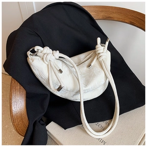 Close-up of white crescent crossbody bag with marble texture and knotted shoulder strap