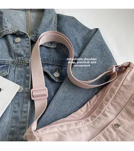 Pink nylon shoulder bag detail featuring an adjustable wide strap and front snap pocket