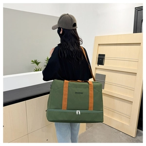 Détail du sac de voyage vert avec sangles oranges et compartiment inférieur séparé