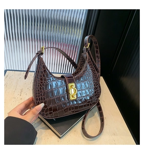 Détail du sac hobo bordeaux à relief crocodile avec fermoir rotatif carré en métal doré