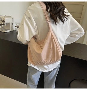 Lightweight pink nylon crossbody bag detail with adjustable strap and spacious design