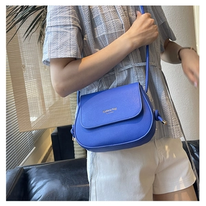 Blue crossbody saddle bag with gold lettering shown from a stylish side view angle