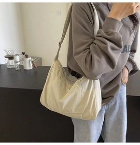 Detailed view of lightweight large capacity beige hobo bag with adjustable canvas strap