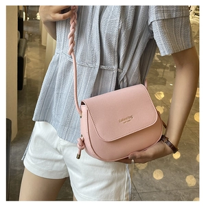 Close-up of pink PU leather crossbody bag featuring a woven strap and gold fashion text