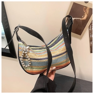 Detail of rainbow striped straw shoulder bag with silver bow and bead tassel charm