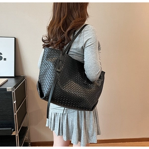 Close-up of black woven leather tote bag showing intricate Intrecciato craftsmanship