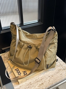 Large khaki nylon tote bag with drawstring pockets and adjustable canvas shoulder strap