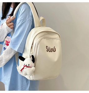 Detail of cream backpack with SUJU logo and white plush puppy charm on side pocket