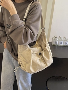 Large beige nylon tote bag with adjustable drawstrings for versatile crossbody wear