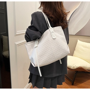 Detailed back view of a white woven tote bag on a model for daily commuting