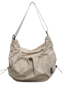 Beige oversized nylon tote bag with drawstring details and adjustable shoulder strap