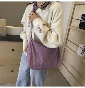 Detail view of purple nylon crossbody bag with large front pocket for daily commute