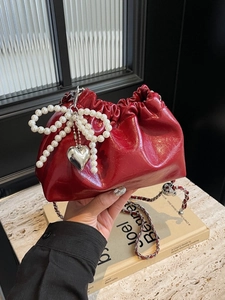 Sac seau élégant en cuir rouge avec nœud en perles et bandoulière chaîne argentée