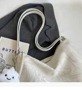 Détail d'un sac cabas à motif marbre blanc avec charme nuage et doubles poignées