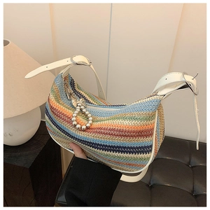 Detail of colorful rainbow woven straw shoulder bag with white leather strap and bead zip pull